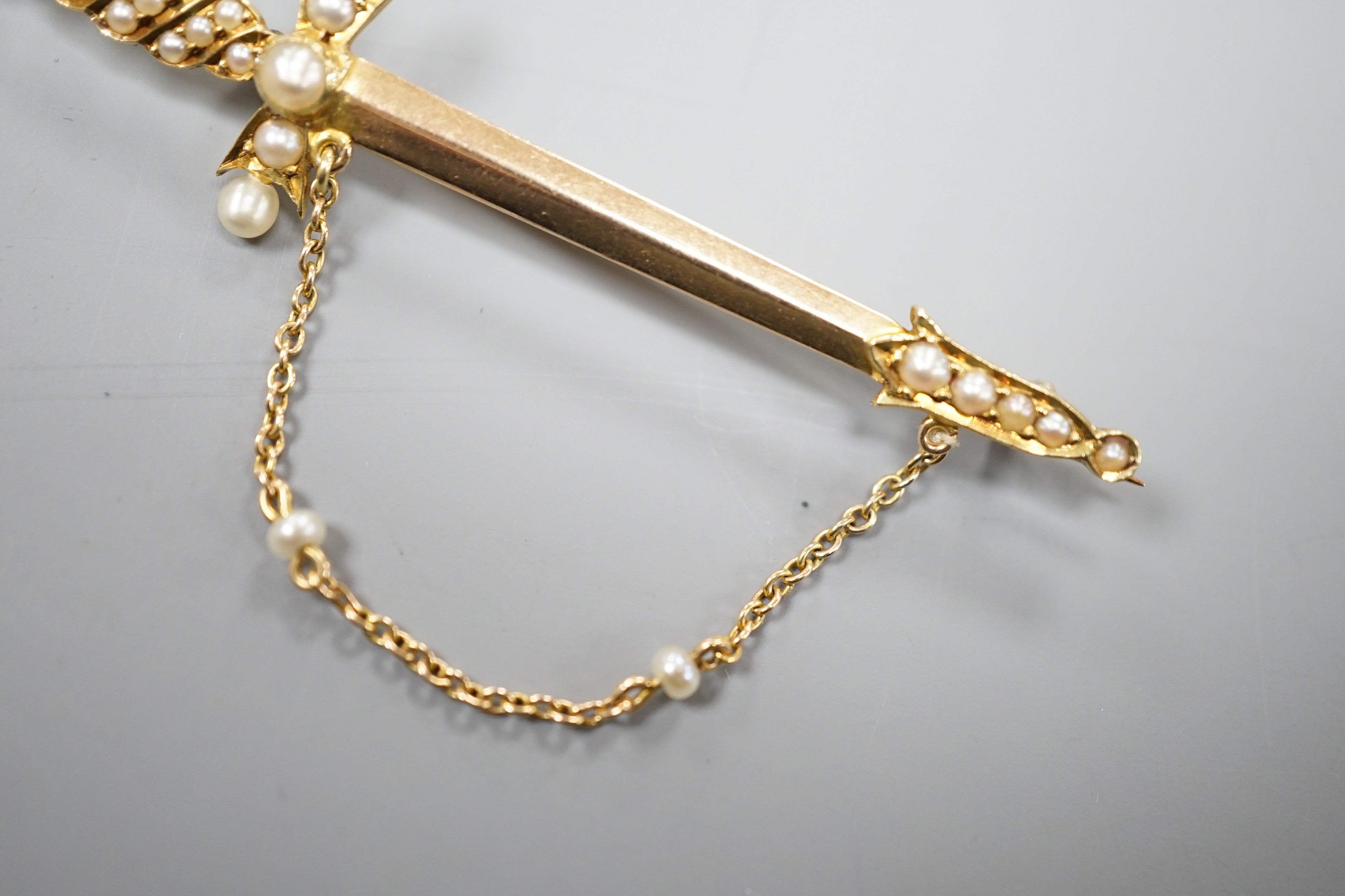 An Edwardian yellow metal and graduated seed pearl set dagger bar brooch, 60mm, gross weight 5 grams.